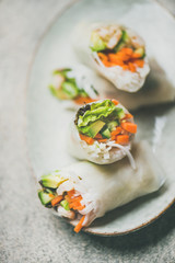 Shrimp and vegetable rice paper spring rolls with sauce and chopsticks on plate, top view, selective focus. Asian cuisine, clean eating, vegetarian, dieting food concept