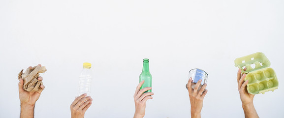 Human hands showing recyclable paper, plastic, glass and aluminum can