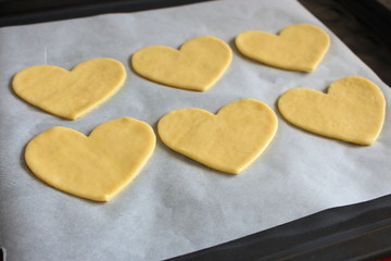 Valentine's day cookies with heart shape. Baked hearts. Sweet love symbol. Cooking surprise. Romantic biscuit gift. Cooking cookies background. Hearts from dough. 