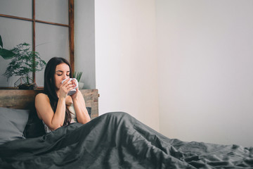 Good morning Woman woke up in bed. Woman drinking coffee in bed