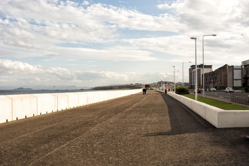 Sea front promenade in the town of Kirkcaldy, Scotland, people walking at a distance