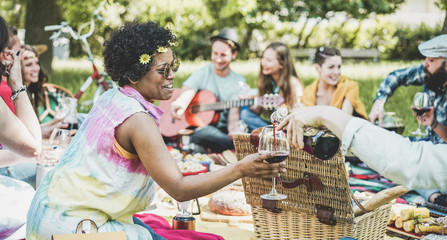 Group of friends making picnic lunch and drinking wine outdoor