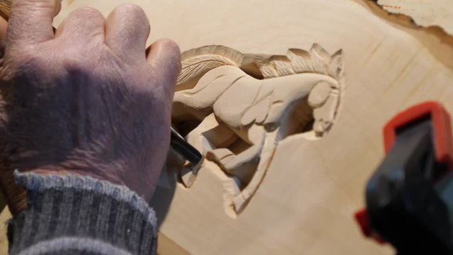 Wood Carver with chisel and hammer.