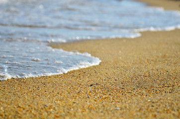 Fototapeta na wymiar Sand beach and wave. Soft Wave Of Blue Ocean On Sandy Beach. Background. Selective focus.