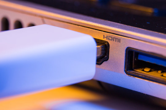 Closeup of HDMI cable plug inserted into port on the side of a laptop
