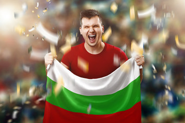 Fototapeta premium Bulgarian fan, fan of a man holding the national flag of Bulgaria in his hands. Soccer fan in the stadium. Mixed media