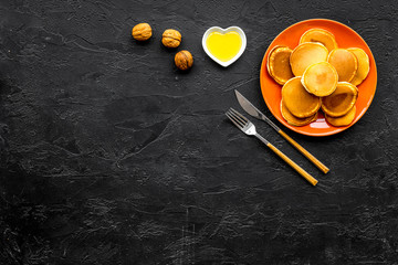 Pile of hot homemade pancakes on bright plate. Black background top view copy space