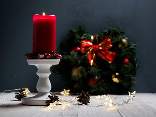 Christmas spruce branch wreath with candle on the wood board