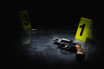 Crime scene concept with a gun and evidence markers, high contrast image