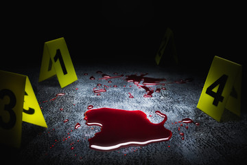 evidence markers on the floor with blood puddle, high contrast image