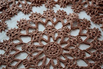 Brown hand hooked coaster. Knitted holders for hot work.