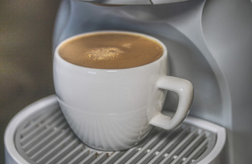 A cup of espresso in a coffee-machine. Close-up