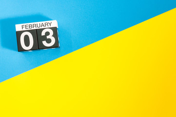 February 3rd. Day 3 of february month, calendar on blue and yellow background flat lay, top view. Winter time. Empty space for text