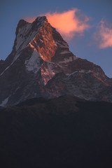 Fototapeta premium Rugged peak with some clouds glowing at sunrise
