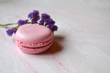 Colorful macaroons on the pink textured table. Tasty background. Sweet beautiful cakes.