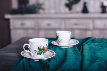 Tea cups on a wooden table with a beautiful velvet tablecloth