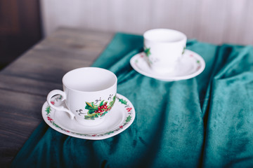 Fototapeta na wymiar Tea cups on a wooden table covered with velvet cloth