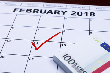 February 14 marked on the calendar and the money set aside for gifts.