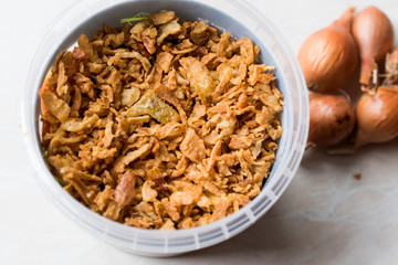 Fried Crispy Onion Flakes in Plastic Package Bowl.