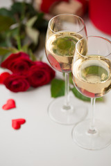Romantic date champagne white wine glasses red beautiful roses, gift jewelry box and heart shape decoration. Valentine`s day date dinner engagement marriage proposal international women day concept