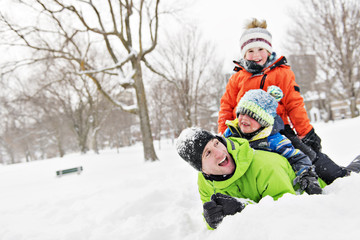 Fototapeta na wymiar Father And Sons In Snowy Landscape