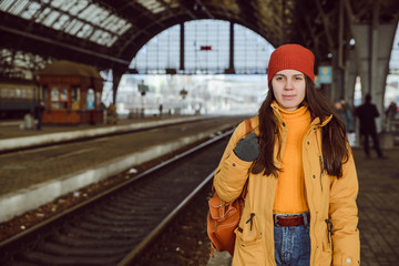 woman walk by railway station - obrazy, fototapety, plakaty