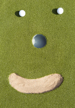 Two golf balls a sand bunker. Looks like a smile symbol. Smily sport. Funny image.