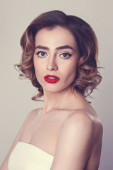 Beauty portrait of pretty girl with curly hair,  cat eye make-up, red lips. Beauty, cosmetics concept. Healthcare.
