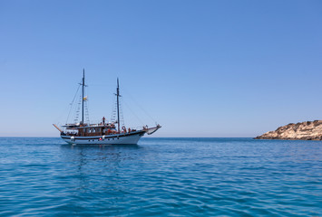 Залив Средиземного моря и плывущий пиратский корабль на нем, виден берег и волны