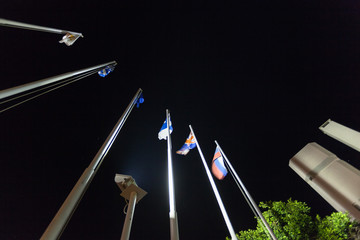 Флаги разных стран на флагштоках на фоне ночного неба
