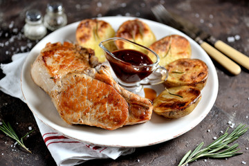 Baked pork chop with potatoes and barbecue sauce. 
