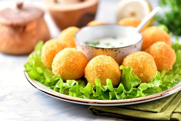 Potato croquettes and yogurt sauce with green onions. Fast food.