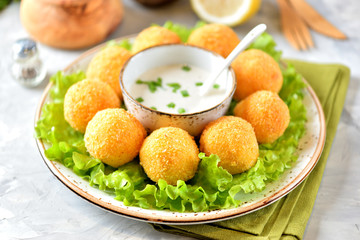 Potato croquettes and yogurt sauce with green onions. Fast food.