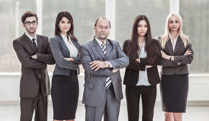 portrait of successful businessman and business team standing together with arms crossed in front of him
