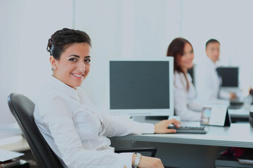Obraz premium Closeup portrait of business woman giving you cute smile with colleagues in background.