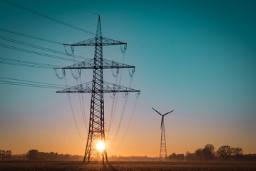 Energiewende - Stromversorgung, Stromleitungen vor aufgehender Sonne