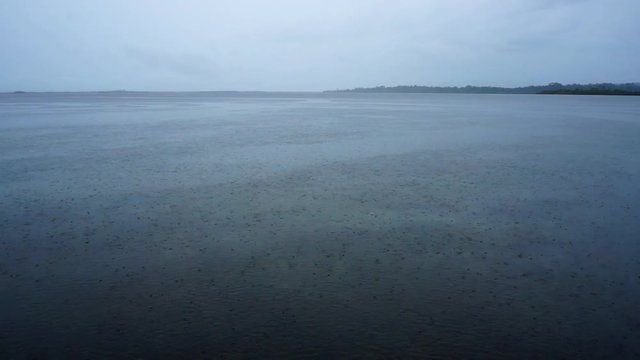 Cloudy weather with rain on calm sea and islands in background, Caribbean sea, Panama, Central America, 50fps.