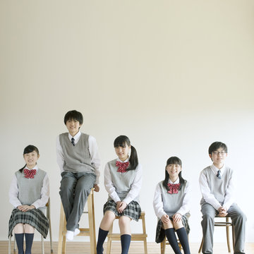 椅子に座り微笑む中学生