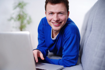 sympathischer Mann auf der Couch am Laptop 