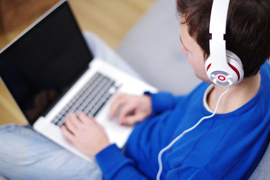 Musik h&ouml;ren mit Kopfh&ouml;rern am Laptop 