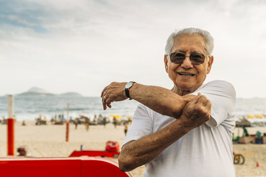 Close Up Of Older Man Stretching Triceps At Beachside In Rio De Janeiro, Brazil