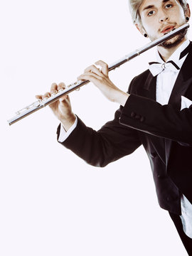 Male flutist wearing tailcoat plays flute