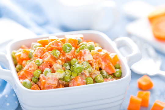 Green peas stewed with carrots in creamy milk white sauce, vegetable stew