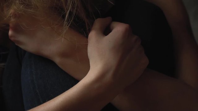 The girl trembling grabs herself by the hand