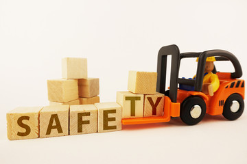 Safety at work concept with orange forklift with wooden blocks on white background
