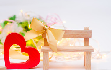 wooden heart with a bow on a bench on a white background. Valentine's Day