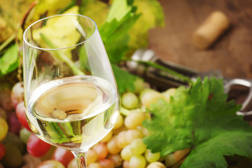 Dry white wine in glass, still life in rustic style, vintage wooden background, selective focus