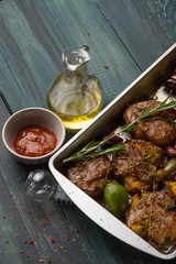 Baked tasty young potatoes baked with herbs, spices, thyme and olives. Traditional recipe. Side view.