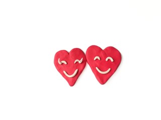 Couple red hearts made from plasticine clay on white background,Smiling face dough