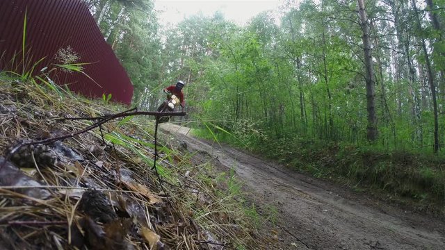 Biker on enduro bike riding motocross in the forest.